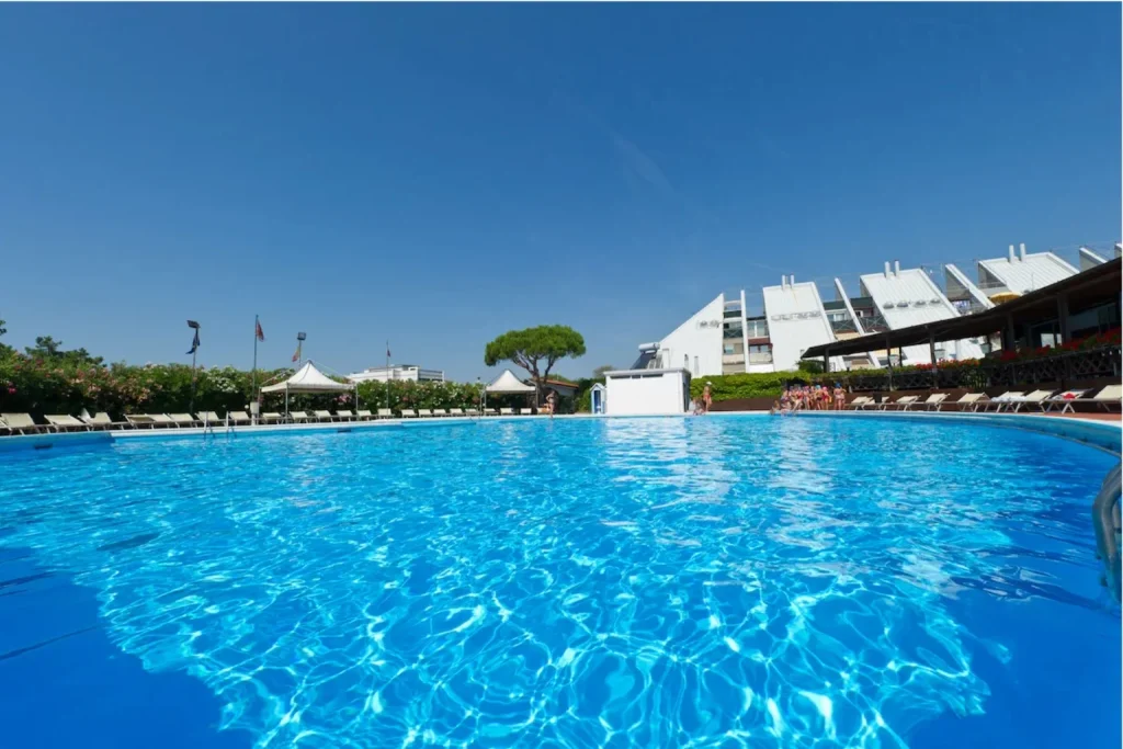 Large outdoor swimming pool at Ca’ del Moro with sun loungers and landscaped surroundings on Venice Lido.