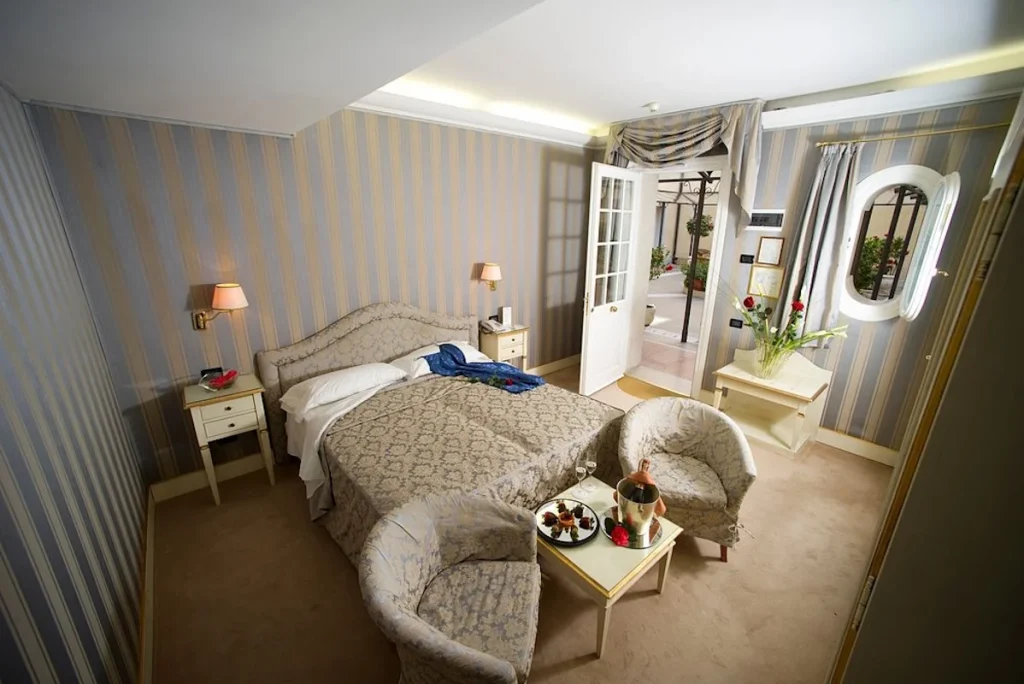 Classic room with traditional Venetian décor, comfortable seating, and elegant furnishings at Hotel Carlton on the Grand Canal in Venice, Italy.