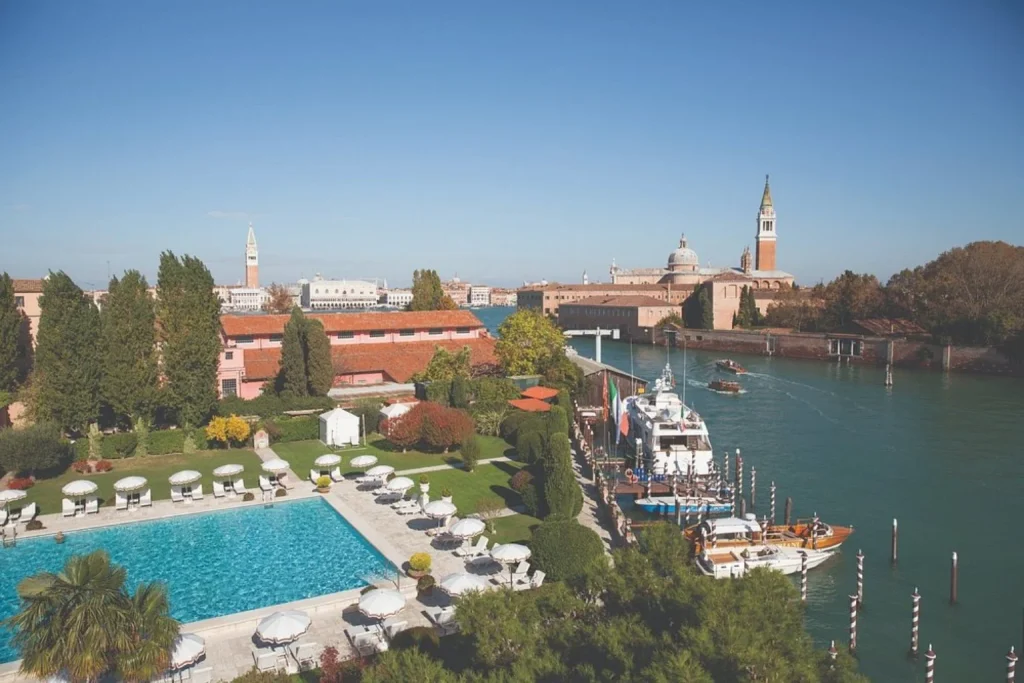 Outdoor swimming pool at Hotel Cipriani with views across the Venetian Lagoon and historic Venice skyline.