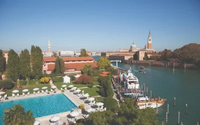 Outdoor swimming pool at Hotel Cipriani with views across the Venetian Lagoon and historic Venice skyline.