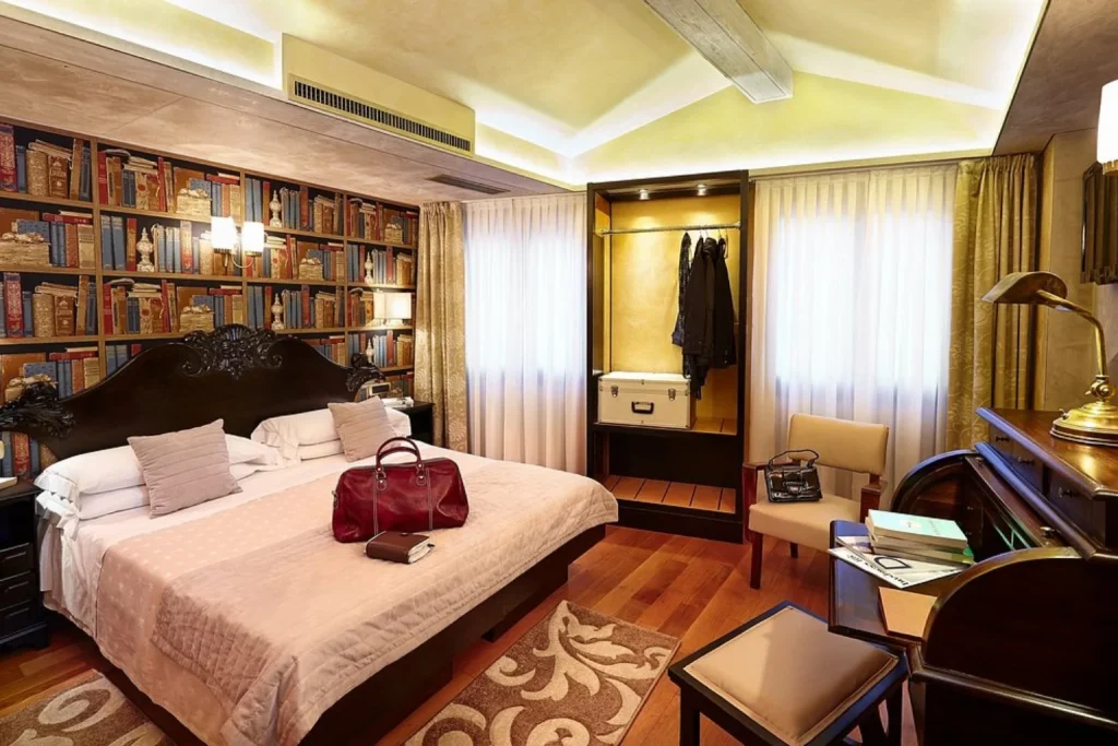 Elegant bedroom with library-style wall at Hotel Saturnia & International in Venice