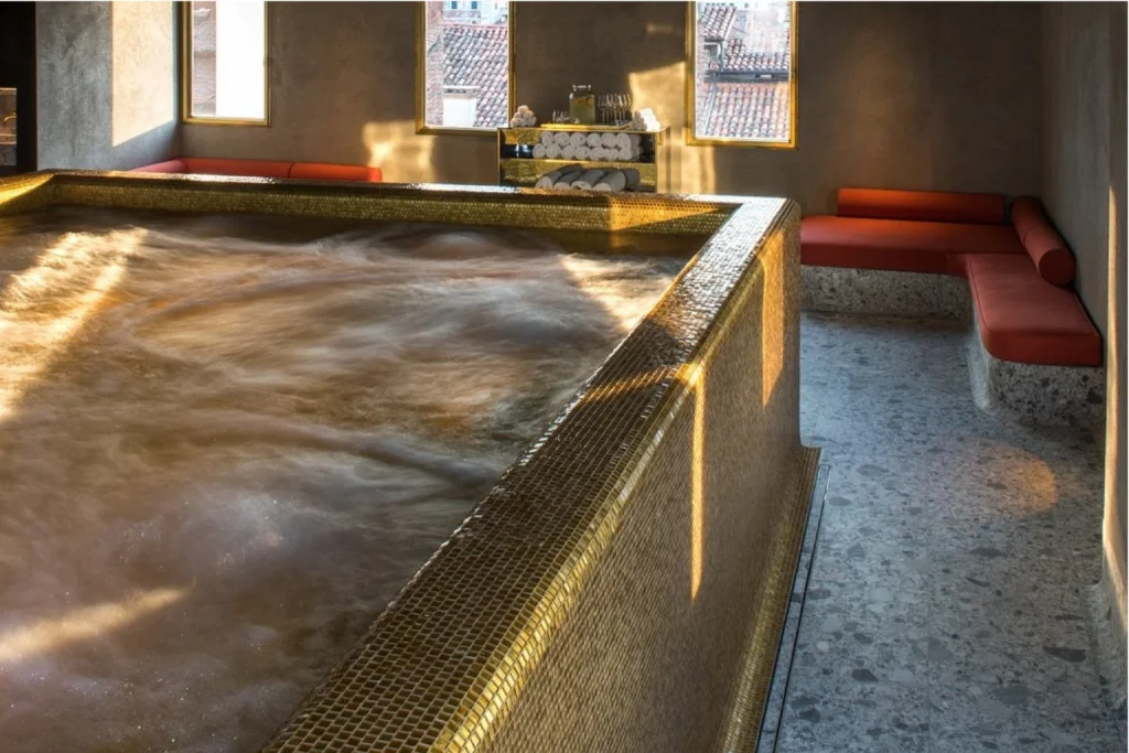 Atmospheric indoor spa pool at Nolinski Venezia, surrounded by minimalist interiors and views over Venice rooftops.