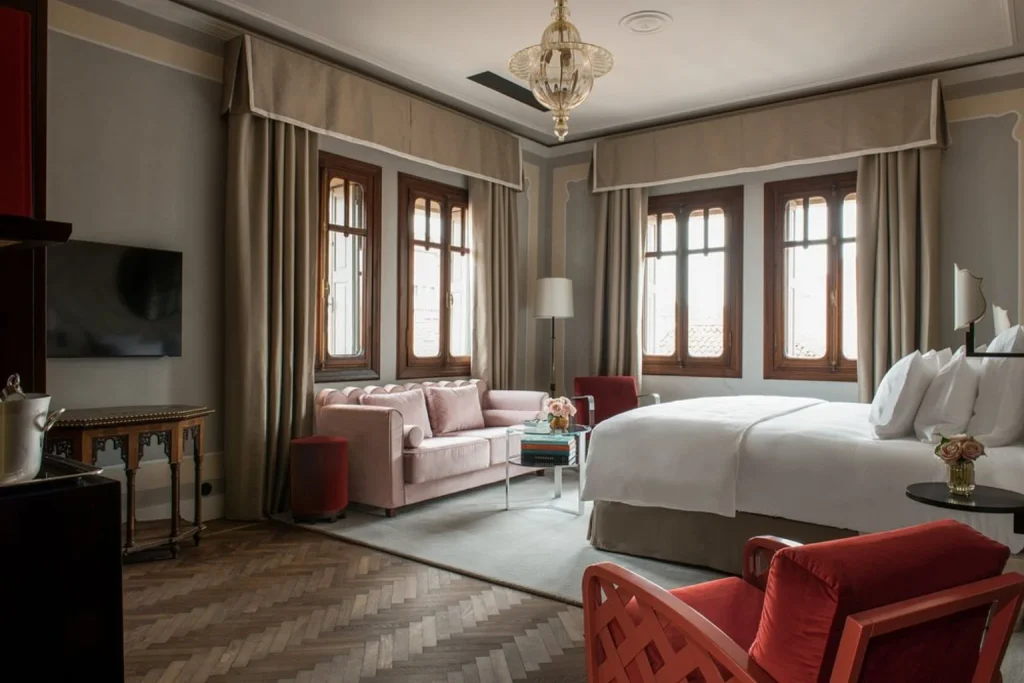 Elegant suite with a spacious sitting area, classic wooden windows and refined interiors at Nolinski Venezia in Venice.