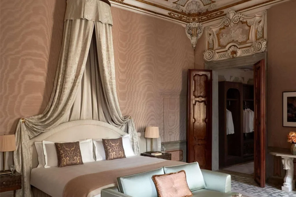 Luxury bedroom with canopy bed and ornate historic ceiling at Orient Express Venezia in Venice