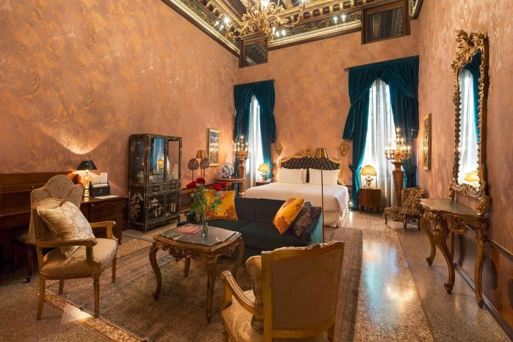 Opulent room with ornate furnishings, rich patterned walls, antique-style decor, elegant mirrors, and a classic Venetian interior at Palazzo Venart Luxury Hotel Venice
