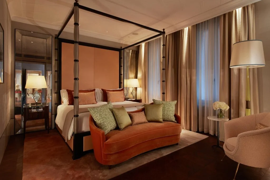 Sophisticated suite bedroom with a four-poster bed, plush seating and refined contemporary décor, The St. Regis Venice, Venice.