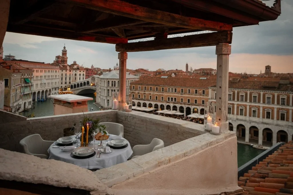 Intimate rooftop terrace with private dining and panoramic views over the Grand Canal and historic rooftops, The Venice Venice Hotel, Venice.