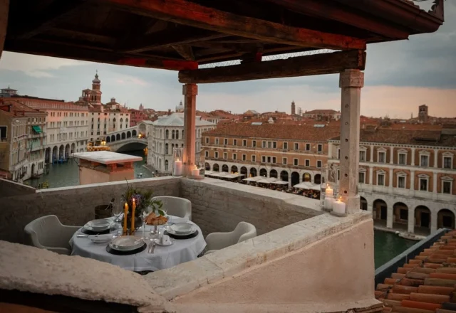 Intimate rooftop terrace with private dining and panoramic views over the Grand Canal and historic rooftops, The Venice Venice Hotel, Venice.